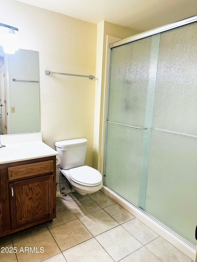 full bath with toilet, tile patterned floors, a shower stall, and vanity