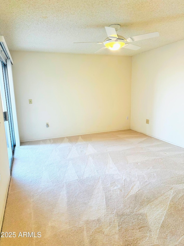 unfurnished room featuring a ceiling fan, light colored carpet, and a textured ceiling