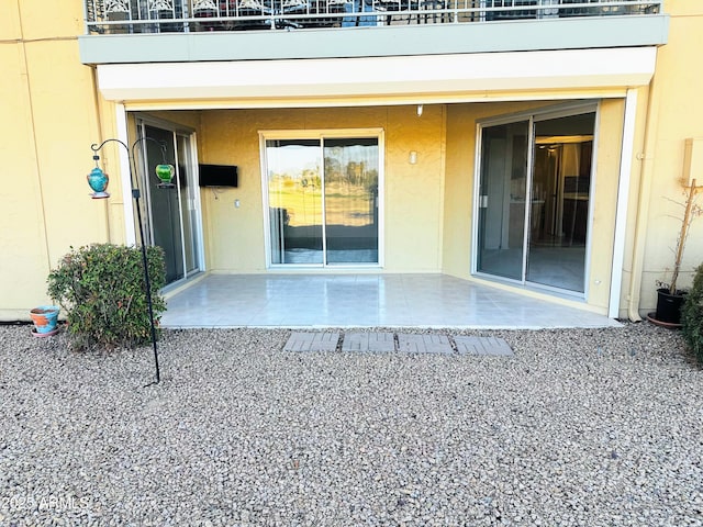 property entrance with a patio area and stucco siding