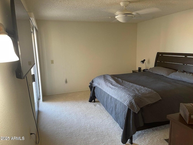 bedroom featuring light colored carpet, a textured ceiling, and baseboards