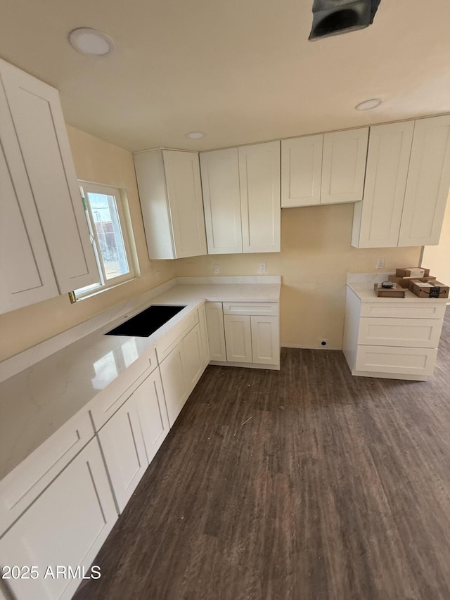 kitchen with white cabinetry, dark wood-type flooring, and black electric cooktop