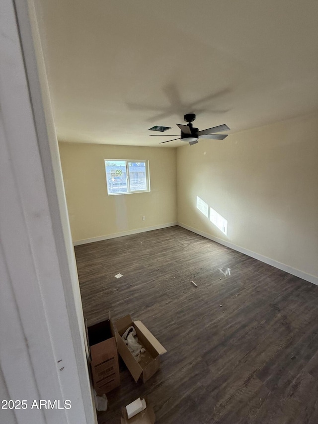 empty room with ceiling fan and dark hardwood / wood-style floors