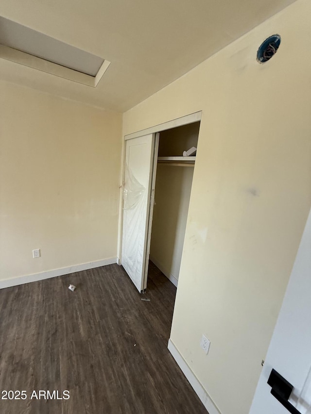 unfurnished bedroom featuring dark hardwood / wood-style flooring and a closet