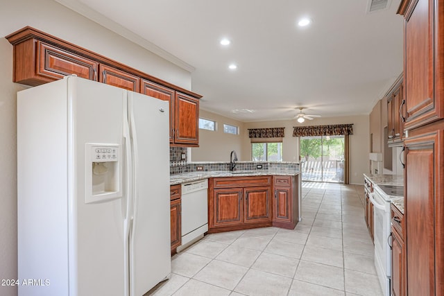 kitchen featuring white appliances, backsplash, ceiling fan, light stone countertops, and kitchen peninsula