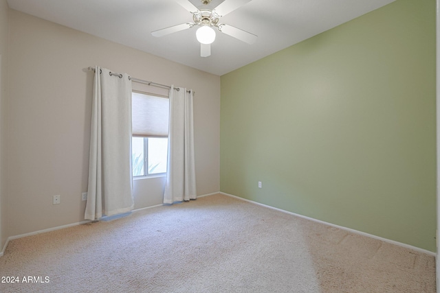 empty room with ceiling fan and light colored carpet