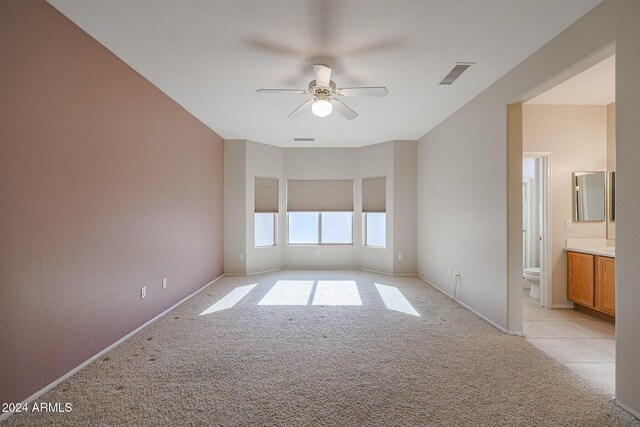 spare room with ceiling fan and light colored carpet