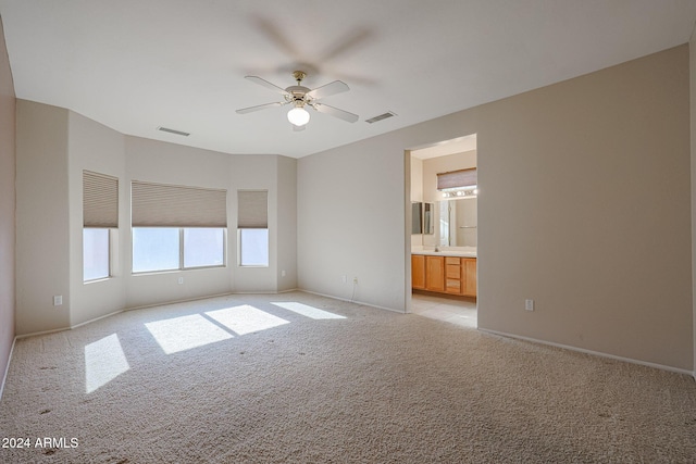 spare room with ceiling fan and light carpet