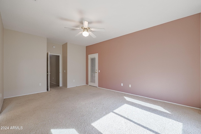 carpeted spare room featuring ceiling fan