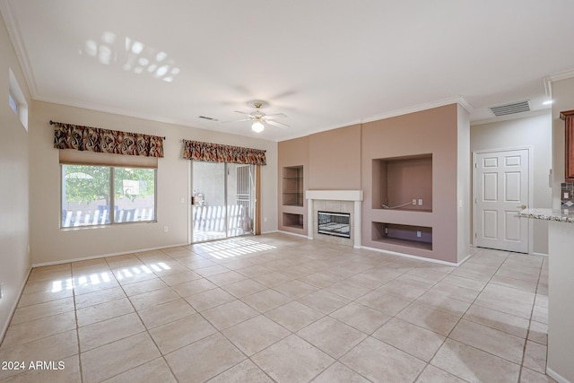 unfurnished living room with ceiling fan, built in features, ornamental molding, and light tile patterned floors