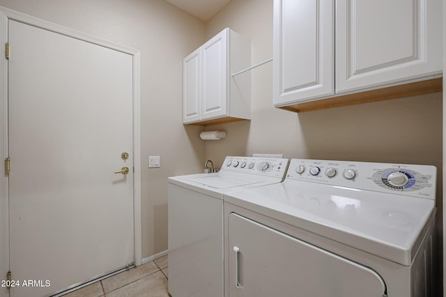 clothes washing area featuring light tile patterned flooring, cabinets, and independent washer and dryer