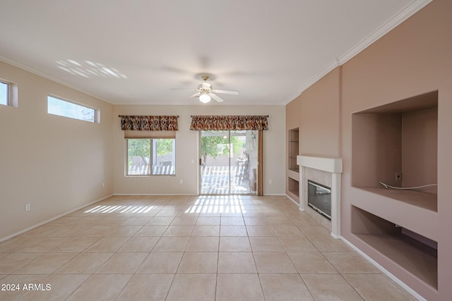 unfurnished living room with ceiling fan, ornamental molding, light tile patterned floors, and a tiled fireplace