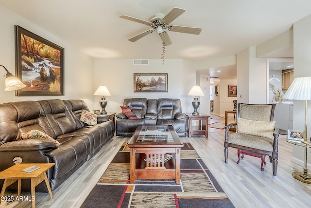 living room featuring ceiling fan and light hardwood / wood-style flooring