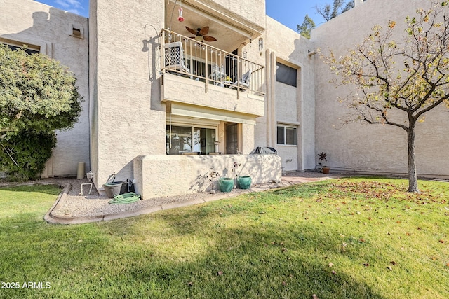 exterior space featuring ceiling fan, a lawn, and a balcony