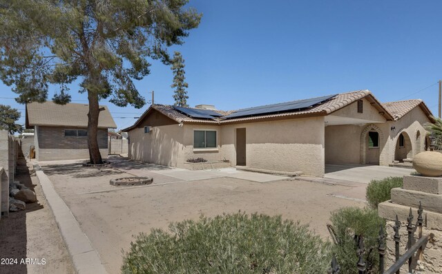 view of front facade featuring a patio and solar panels