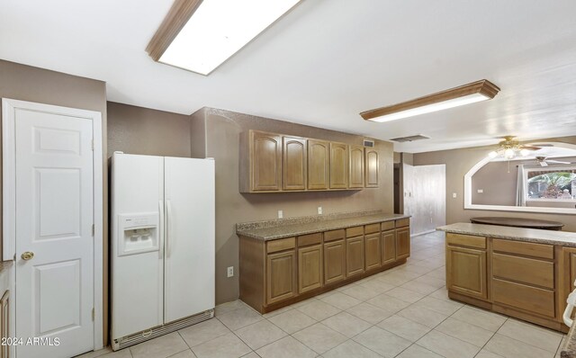 kitchen with ceiling fan, white refrigerator with ice dispenser, and light tile patterned floors