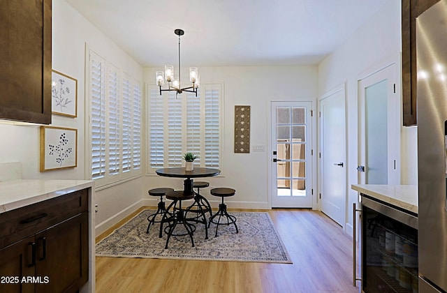 4039 E Paradise Dr, Phoenix, AZ 85028 - dining space featuring beverage cooler, light wood-type flooring, a chandelier, and baseboards