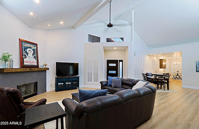4039 E Paradise Dr, Phoenix, AZ 85028 - living area with light wood-type flooring, a glass covered fireplace, high vaulted ceiling, baseboards, and a chandelier