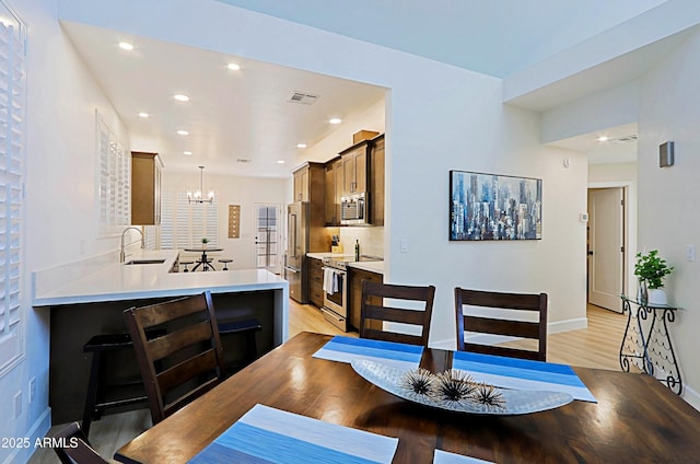4039 E Paradise Dr, Phoenix, AZ 85028 - dining area with a chandelier, light wood-style floors, baseboards, and recessed lighting