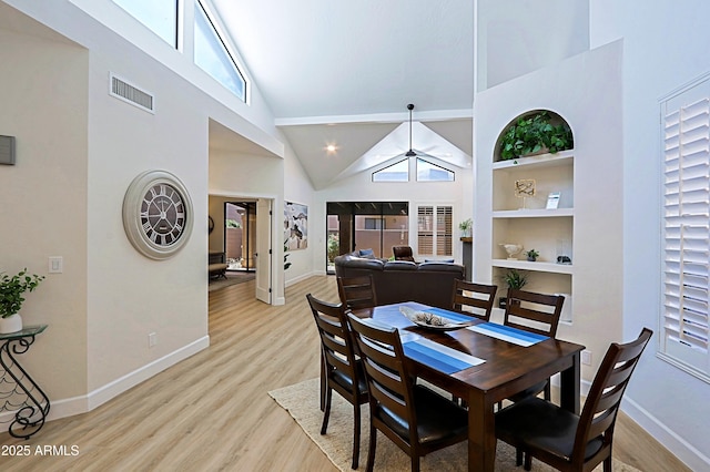 4039 E Paradise Dr, Phoenix, AZ 85028 - dining room featuring baseboards, high vaulted ceiling, light wood-style floors, healthy amount of natural light, and built in shelves