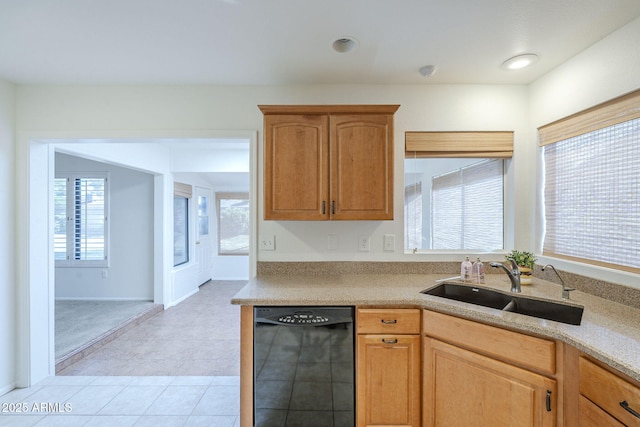 kitchen featuring baseboards, a sink, dishwasher, and light countertops