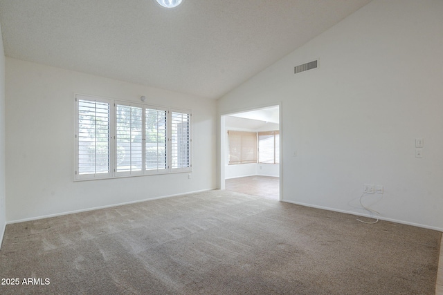 carpeted spare room featuring baseboards, high vaulted ceiling, and visible vents