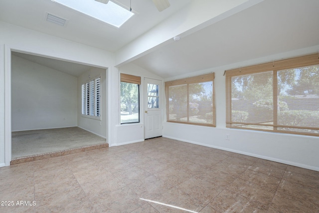 interior space featuring baseboards, tile patterned flooring, lofted ceiling with skylight, and visible vents
