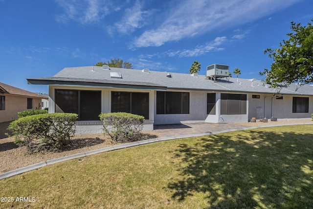 rear view of property with a yard, central AC, a patio area, and a sunroom
