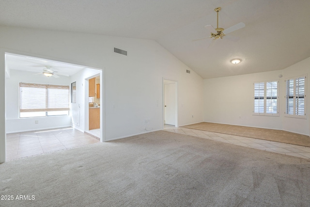spare room with light tile patterned flooring, a ceiling fan, visible vents, and lofted ceiling