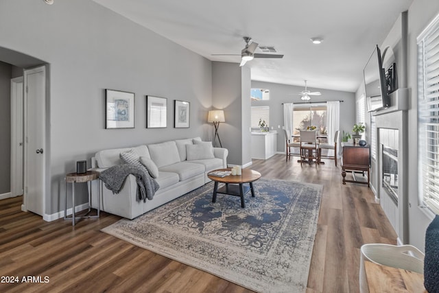 living room featuring ceiling fan, hardwood / wood-style floors, and vaulted ceiling