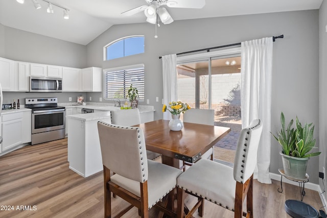 dining room featuring light wood-type flooring, ceiling fan, lofted ceiling, and sink