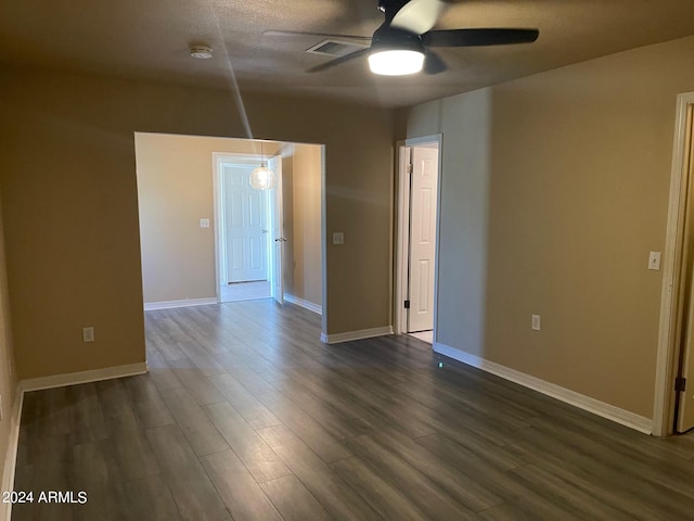 unfurnished room with ceiling fan and dark hardwood / wood-style flooring