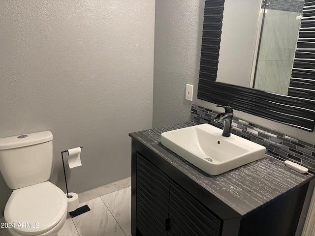 bathroom featuring backsplash, vanity, and toilet