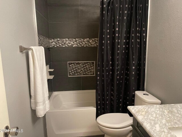 full bathroom with vanity, shower / bath combo with shower curtain, and toilet