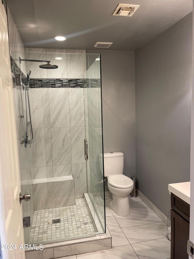 bathroom with walk in shower, vanity, and toilet