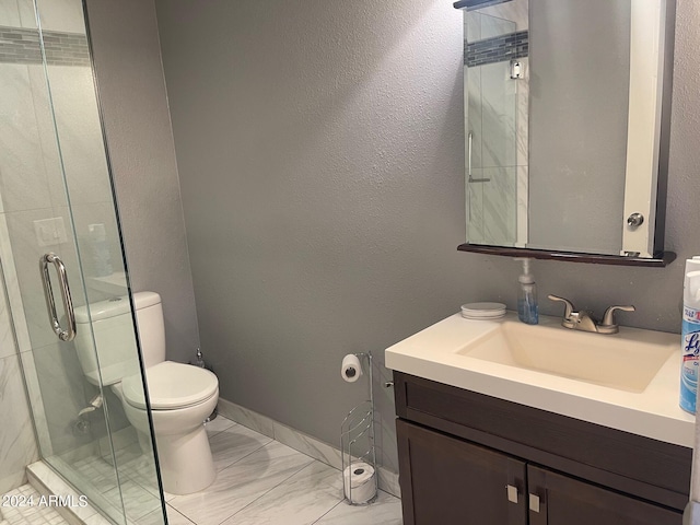 bathroom featuring toilet, a shower with door, and vanity