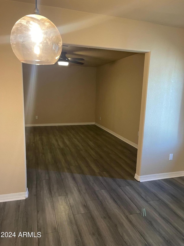 spare room featuring ceiling fan and dark wood-type flooring