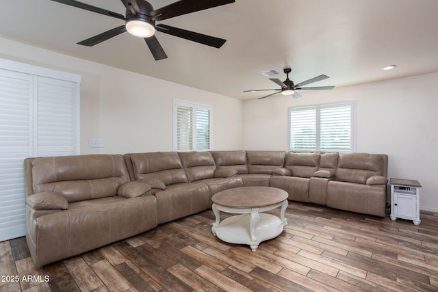 living room featuring ceiling fan and dark hardwood / wood-style flooring