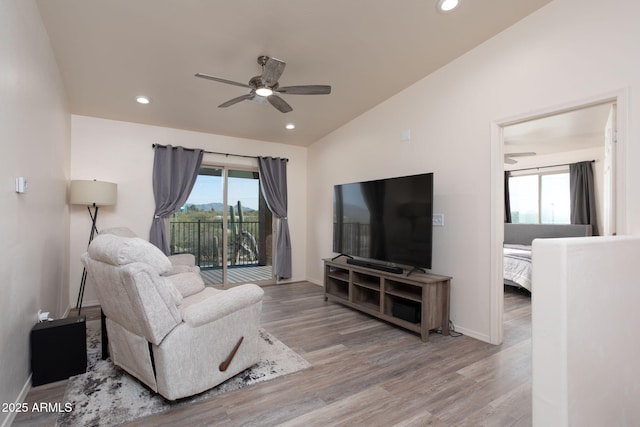 living room with ceiling fan, vaulted ceiling, and hardwood / wood-style floors