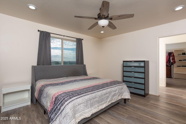 bedroom with ceiling fan, hardwood / wood-style floors, a closet, and a walk in closet