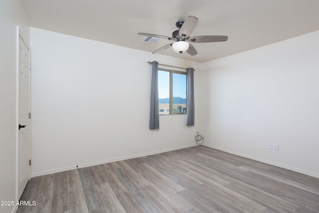 spare room with ceiling fan and light wood-type flooring