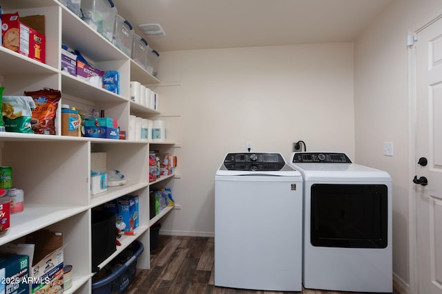 clothes washing area featuring dark hardwood / wood-style flooring and washer and clothes dryer