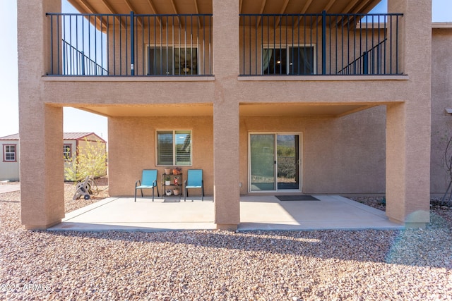 rear view of house featuring a balcony and a patio