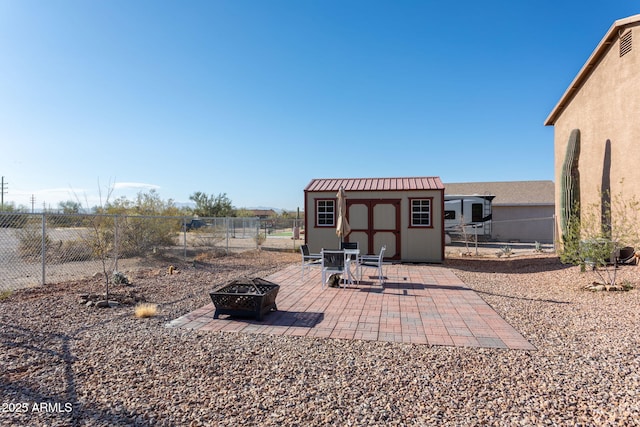 view of patio / terrace with an outdoor fire pit and a storage shed