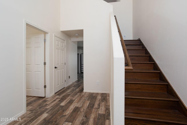 stairway with hardwood / wood-style flooring and a high ceiling