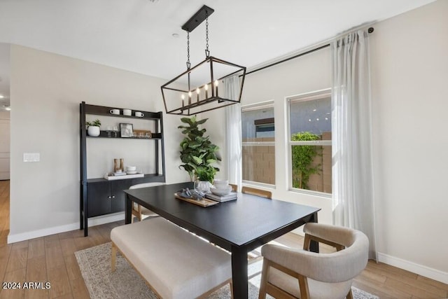 dining space featuring light wood-type flooring and a chandelier