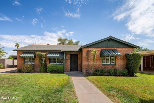 ranch-style house with brick siding and a front lawn