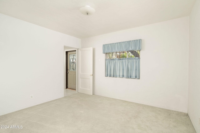 unfurnished room featuring light colored carpet