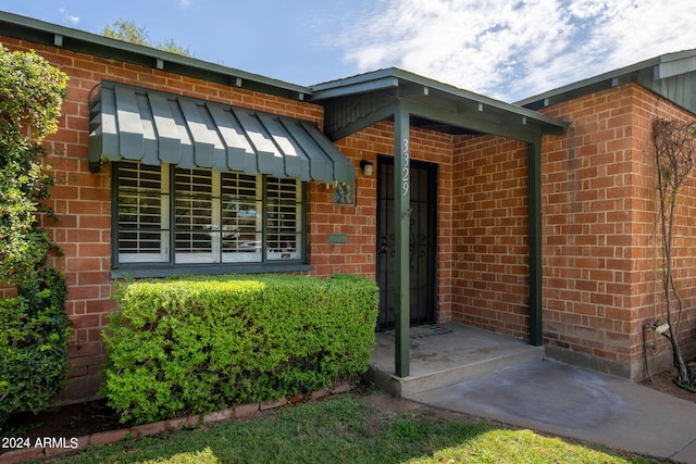 doorway to property with brick siding