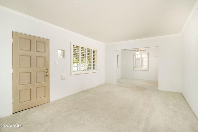 spare room featuring ceiling fan, ornamental molding, and light carpet