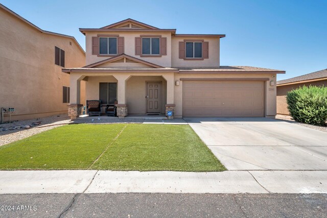 view of front of property with a front yard and a garage